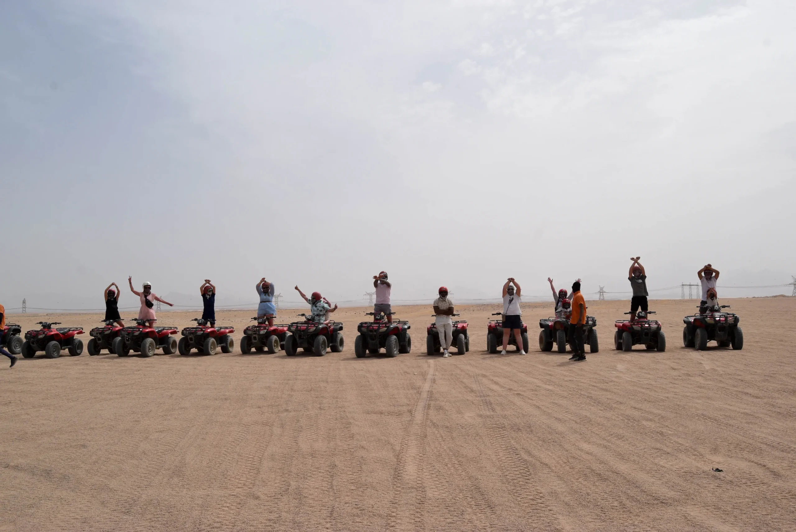 Quad rijden Hurghada: groep toeristen op rode quads in de woestijn bij Hurghada, Egypte