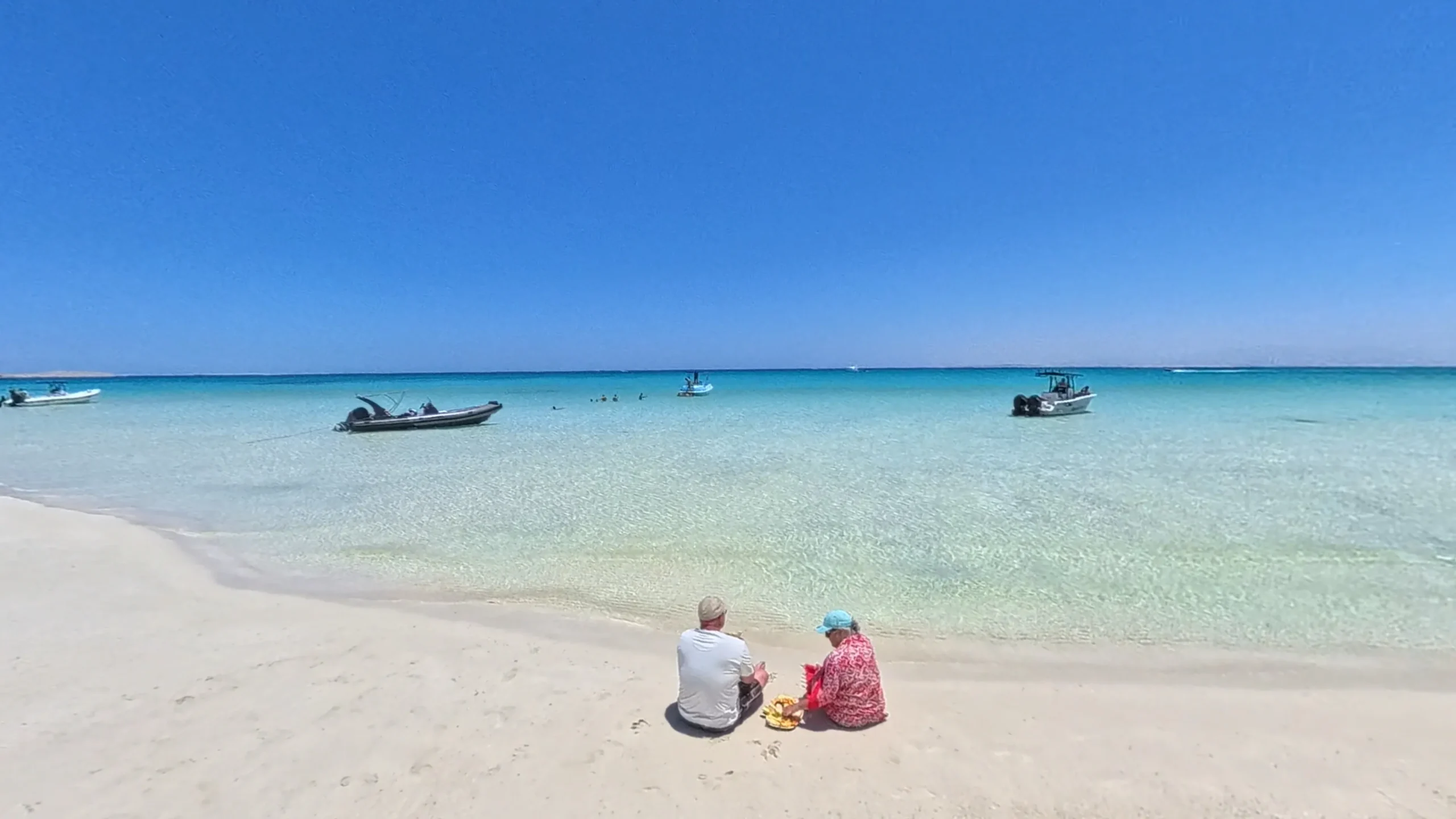 Koppel ontspant op het witte strand met uitzicht op de Rode Zee in Hurghada, Egypte