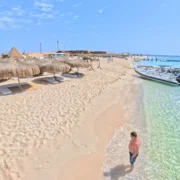 Strand met parasols en helder turquoise water aan de Rode Zee in Hurghada, Egypte