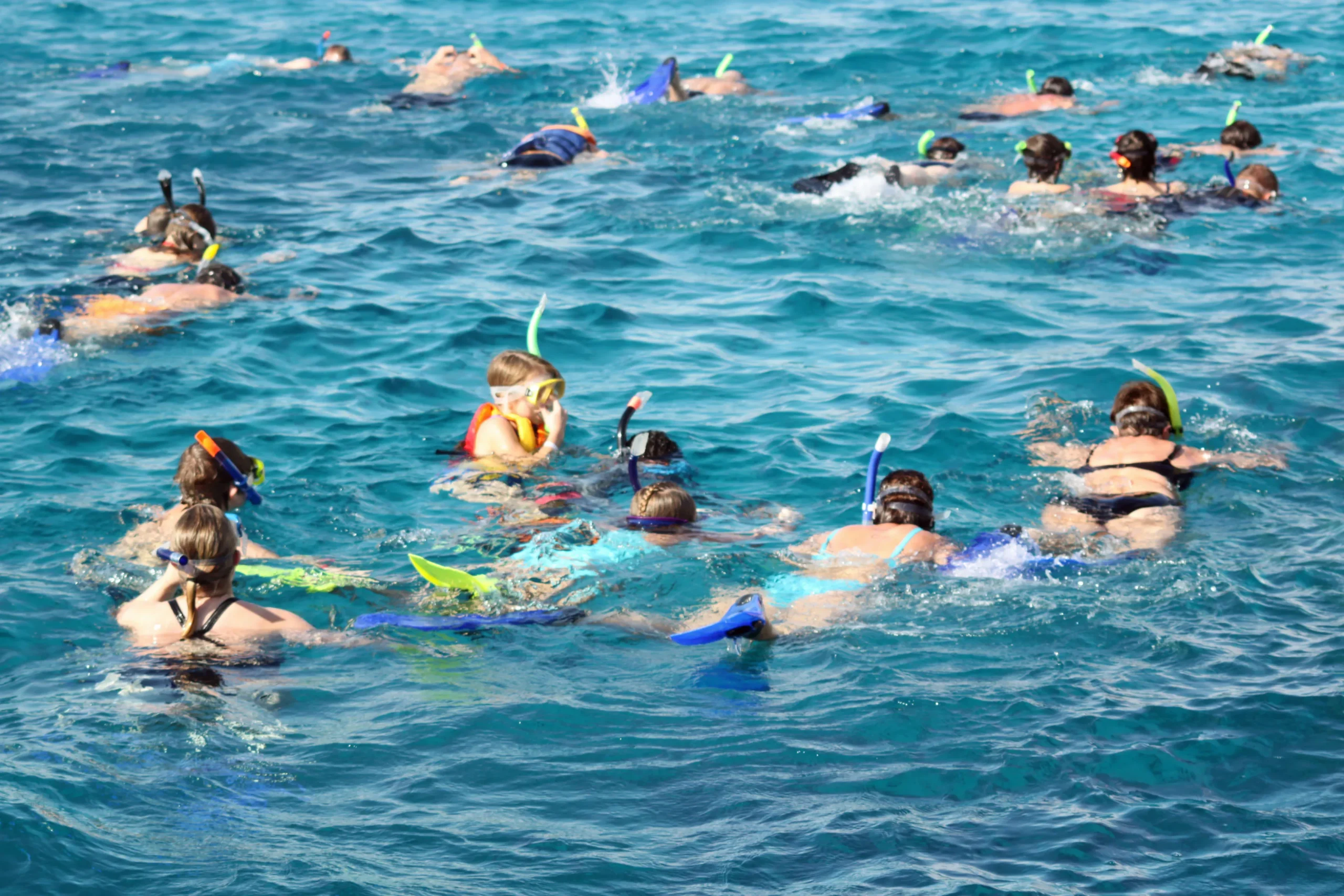 Groep snorkelaars boven een koraalrif in het heldere water van Hurghada, Egypte